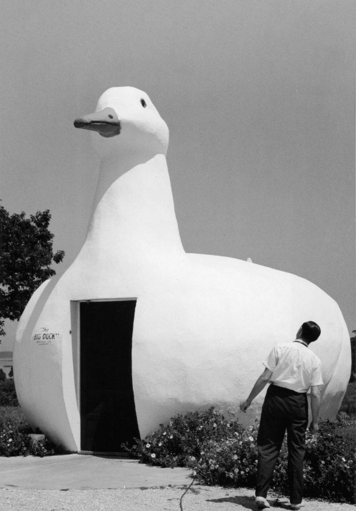 Full-length image of a man looking at a building shaped like a duck, Riverhead, New York. The building was called 'The Big Duck.'   (Photo by Mac Gramlich/Getty Images)
