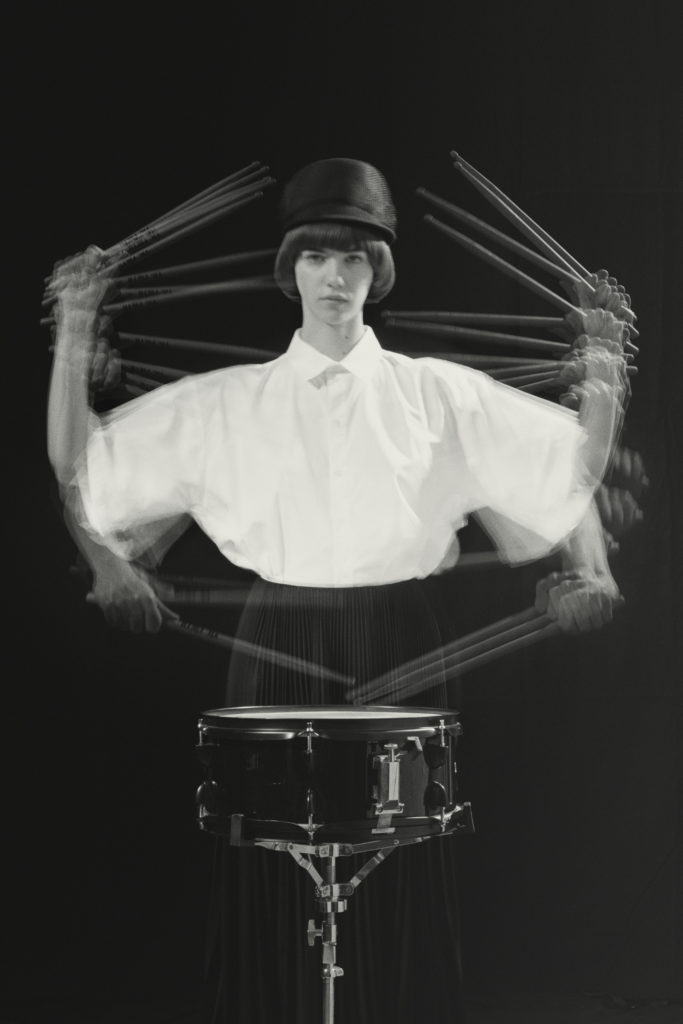 Olivia wears a shirt by MARK KENLY DOMINO TAN, a skirt by BALENCIAGA and a hat by GIGI BURRIS.