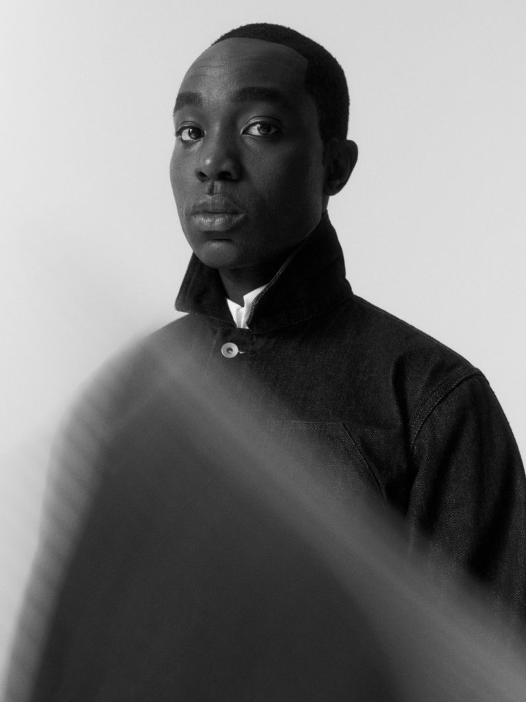 He wears a shirt by MARGARET HOWELL and a jacket by MHL MARGARET HOWELL.
