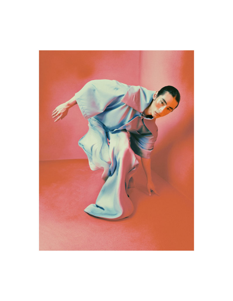 Nash wears a shirt with an oversized collar by WILLY CHAVARRIA and trousers by VINCENT WONG.