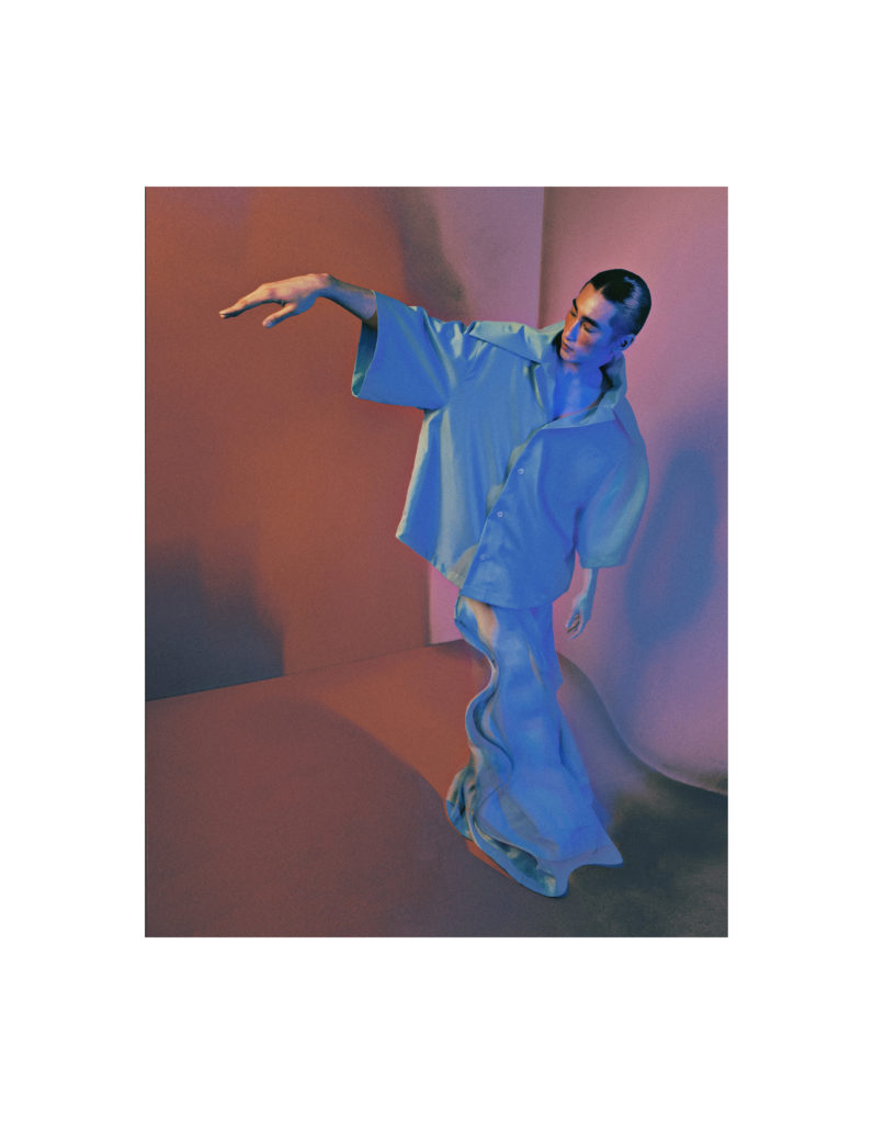 Nash wears a shirt with an oversized collar by WILLY CHAVARRIA and trousers by VINCENT WONG.