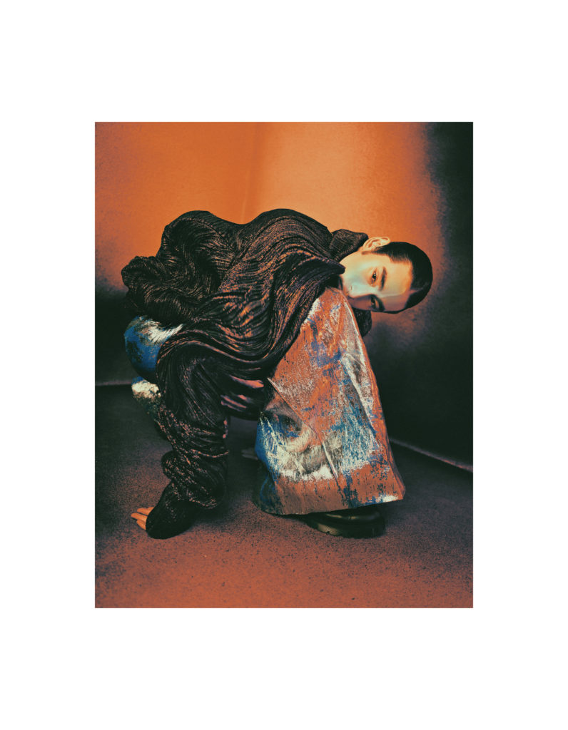 He wears a sweater and oversized trousers by VINCENT WONG and boots by VTMNTS.
